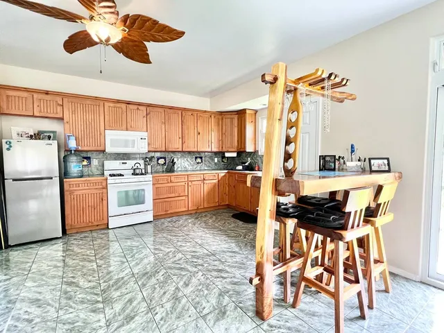 a kitchen with granite countertop a refrigerator and a stove top oven