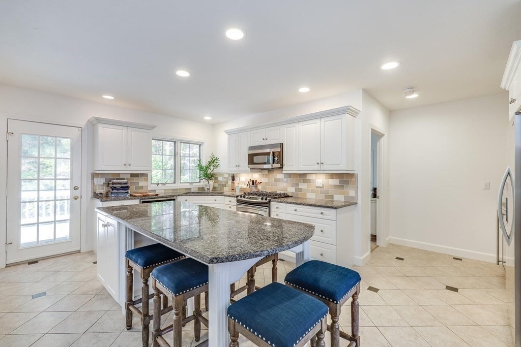 121 Beech Leaf Island Road Centerville, MA 02632 - Photo 24 of 42 a kitchen with granite countertop a table chairs sink and microwave