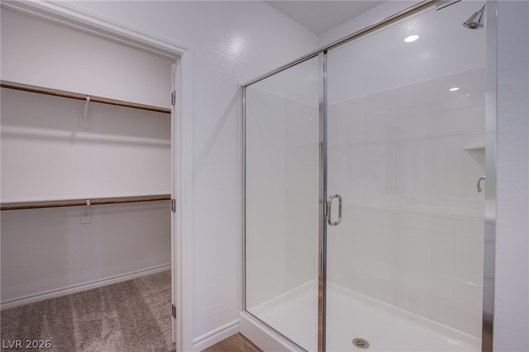2555 Hampton Road, Unit 8201 Henderson, NV 89052 - Photo 19 of 33 A glass-enclosed walk-in shower stands adjacent to a spacious closet with built-in shelving.