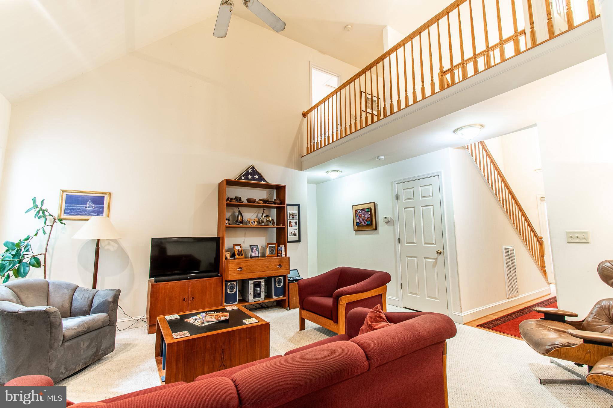 228 Tyler Avenue St. Michaels, MD 21663 - Photo 12 of 44 a living room with furniture a flat screen tv and bookshelf