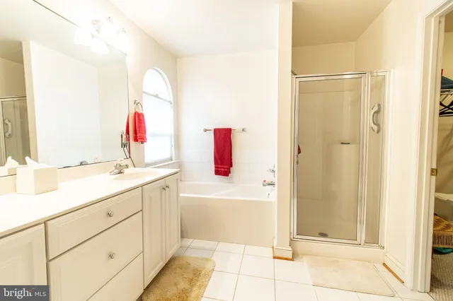 a bathroom with a tub sink and mirror