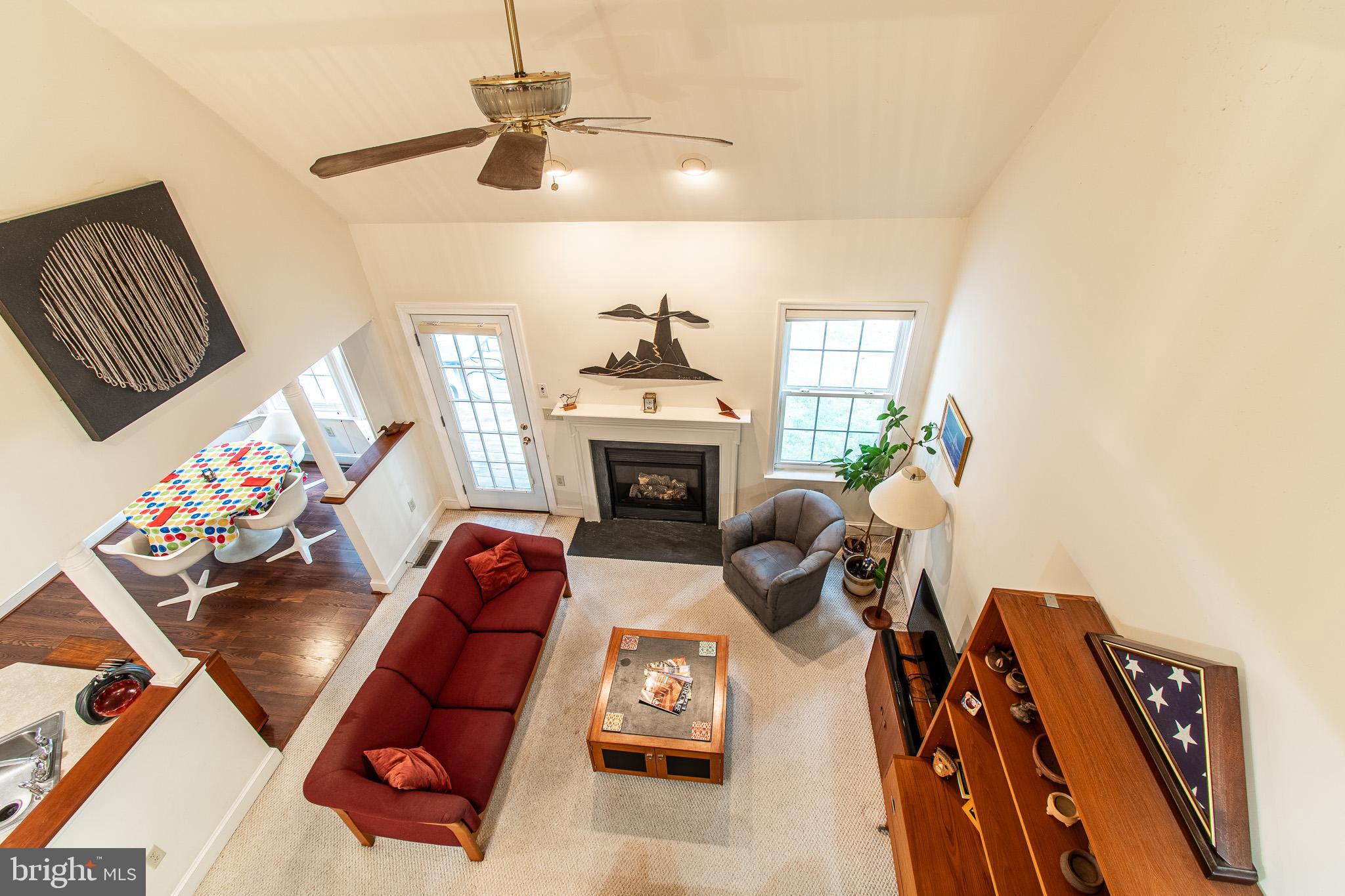 228 Tyler Avenue St. Michaels, MD 21663 - Photo 27 of 44 a living room with furniture a flat screen tv and a fireplace
