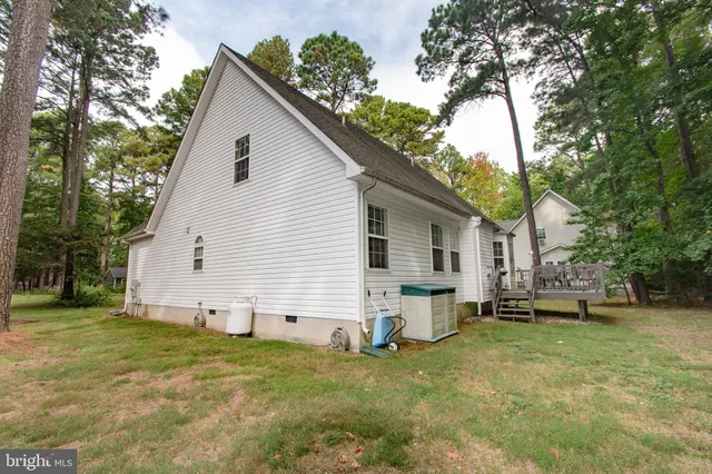 a view of a white house with a yard and a large tree