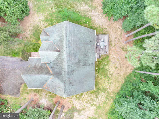 a aerial view of a house with a yard and large trees