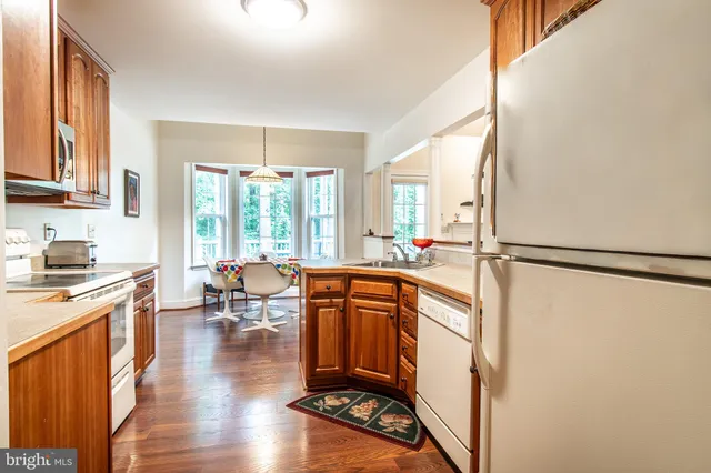 a kitchen with stainless steel appliances granite countertop a refrigerator a stove and a wooden floors