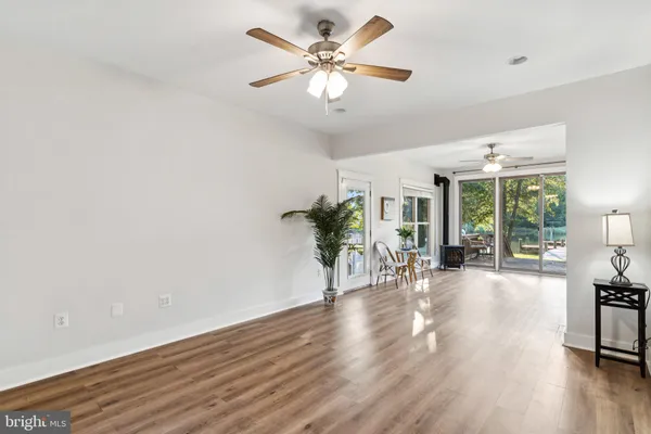 a view of a livingroom with furniture wooden floor and a ceiling fan