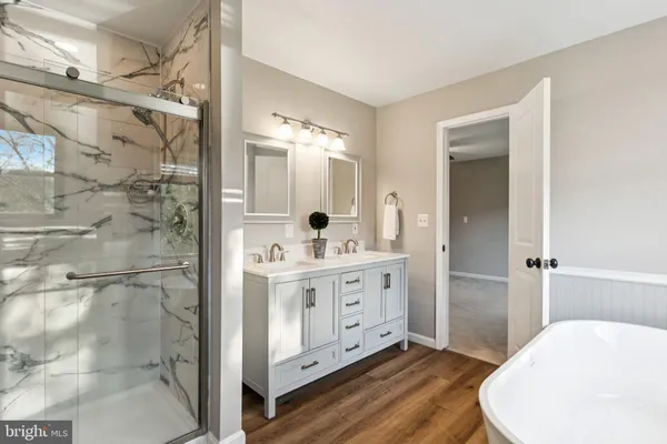 a bathroom with a double vanity sink mirror and shower