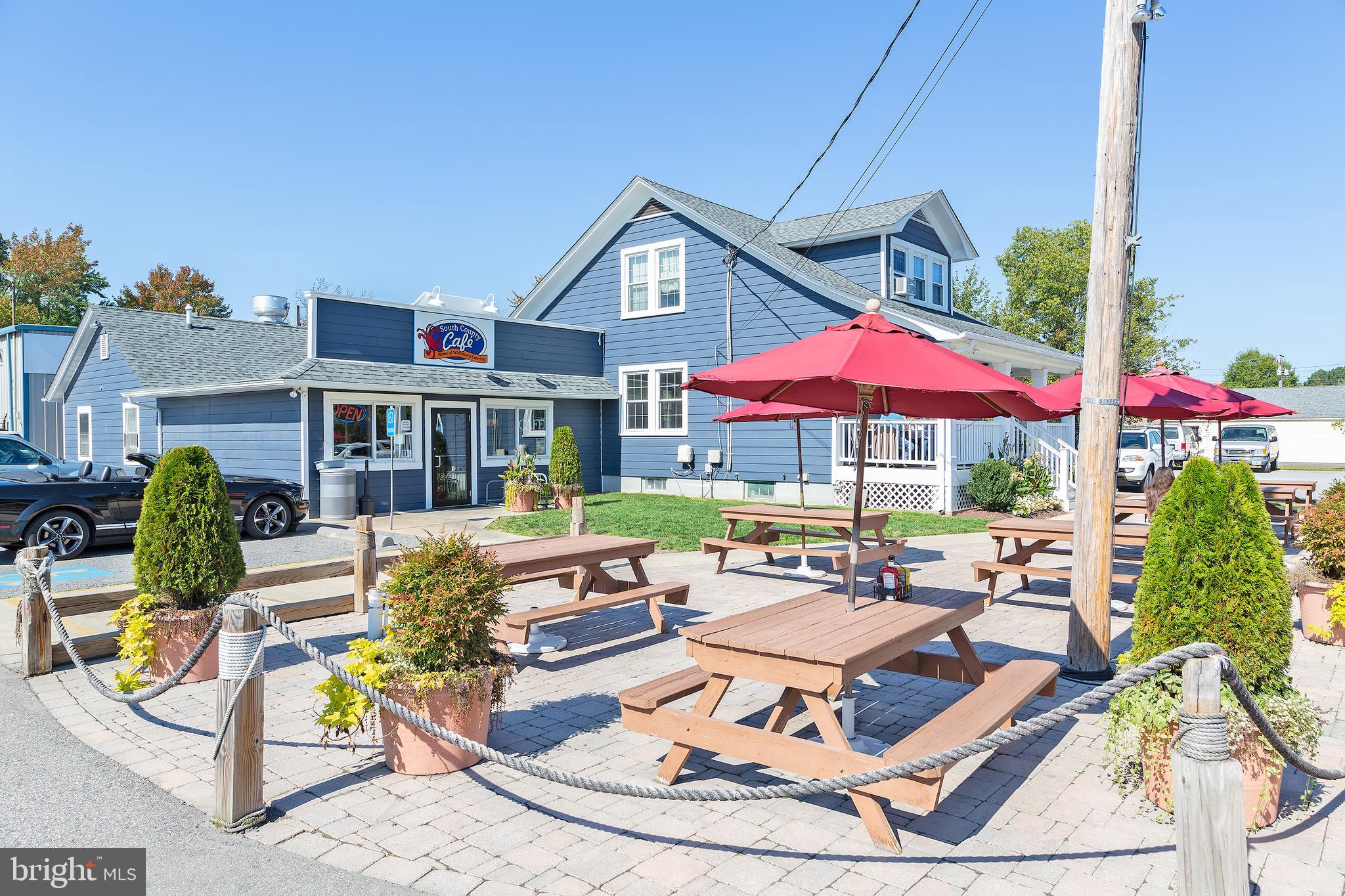 4922 Lerch Drive Shady Side, MD 20764 - Photo 37 of 56 a view of a patio with a dining table and chairs under an umbrella