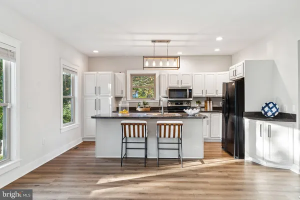 a kitchen with stainless steel appliances kitchen island granite countertop a refrigerator and a stove top oven