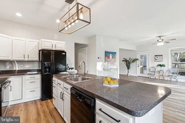 a kitchen with stainless steel appliances granite countertop a sink dishwasher and cabinets with wooden floor