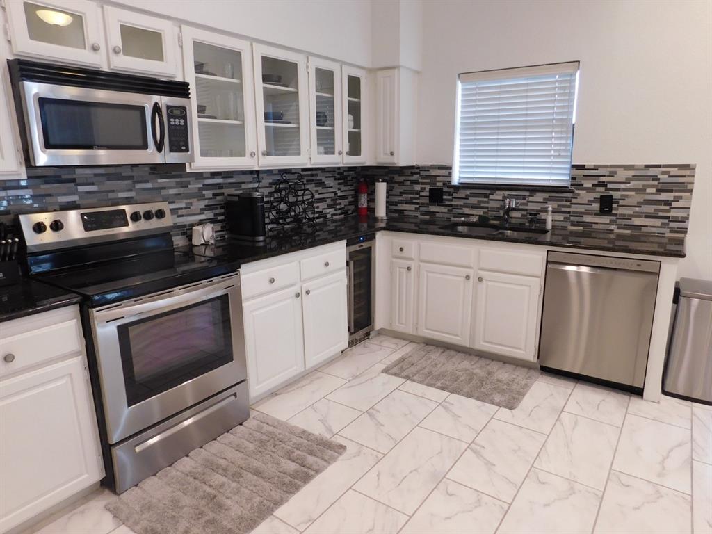 622 Crowley Road Arlington, TX 76012 - Photo 11 of 38 a kitchen with granite countertop a stove sink and cabinets