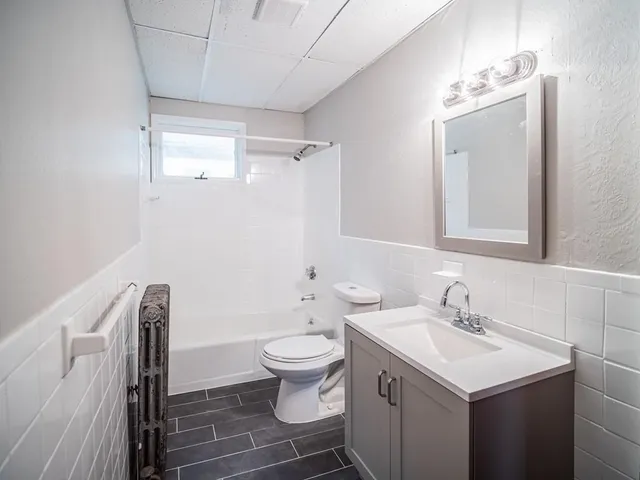 a bathroom with a sink toilet and mirror