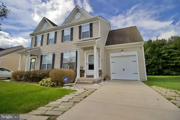 a front view of a house with a garden and plants