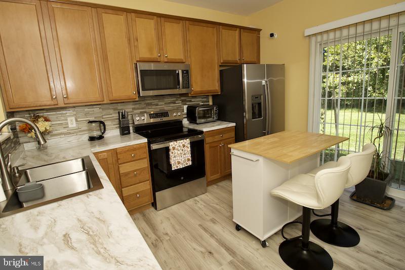 162 Lexington Place Dover, DE 19901 - Photo 12 of 48 a kitchen with stainless steel appliances granite countertop a sink a stove and a refrigerator