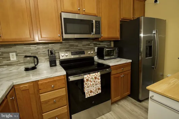 a kitchen with stainless steel appliances granite countertop a stove a refrigerator and a microwave