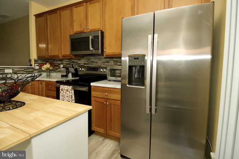 162 Lexington Place Dover, DE 19901 - Photo 18 of 48 a kitchen with a sink a refrigerator and cabinets