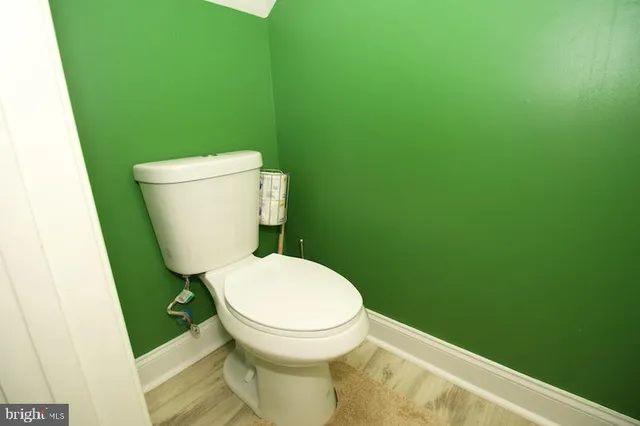 a white toilet sitting next to a shower