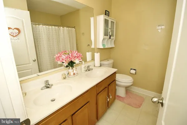 a bathroom with a sink mirror and a toilet