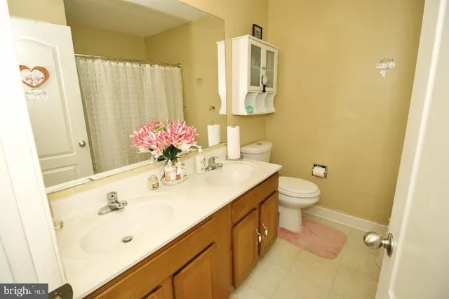 a bathroom with a sink mirror and a toilet