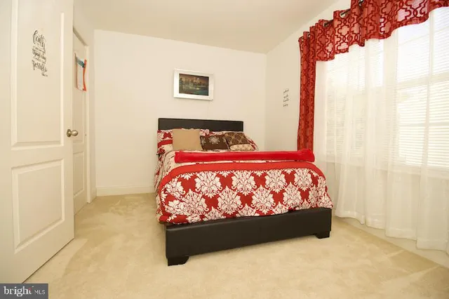 a bed sitting in a bedroom next to a window