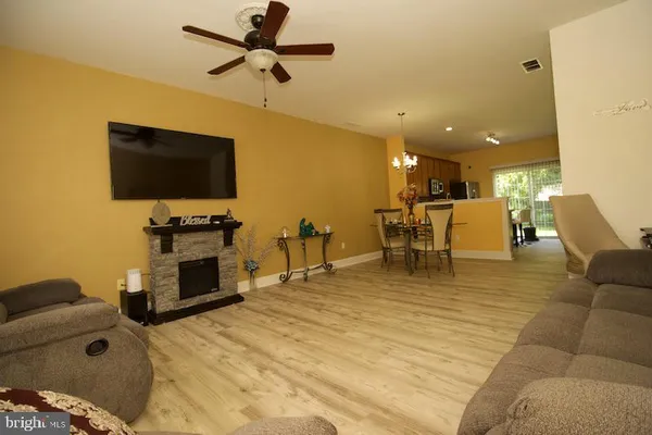 a living room with furniture and a flat screen tv with kitchen view