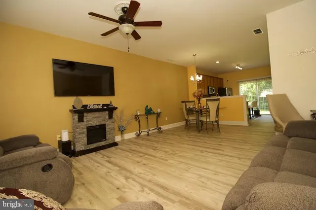 a living room with furniture and a flat screen tv with kitchen view