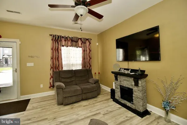 a living room with furniture a flat screen tv and a fireplace