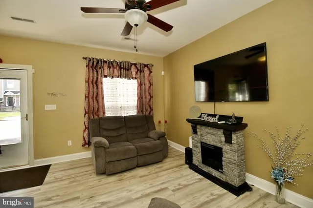 a living room with furniture a flat screen tv and a fireplace