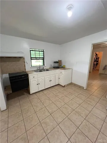 a kitchen with white cabinets and appliances
