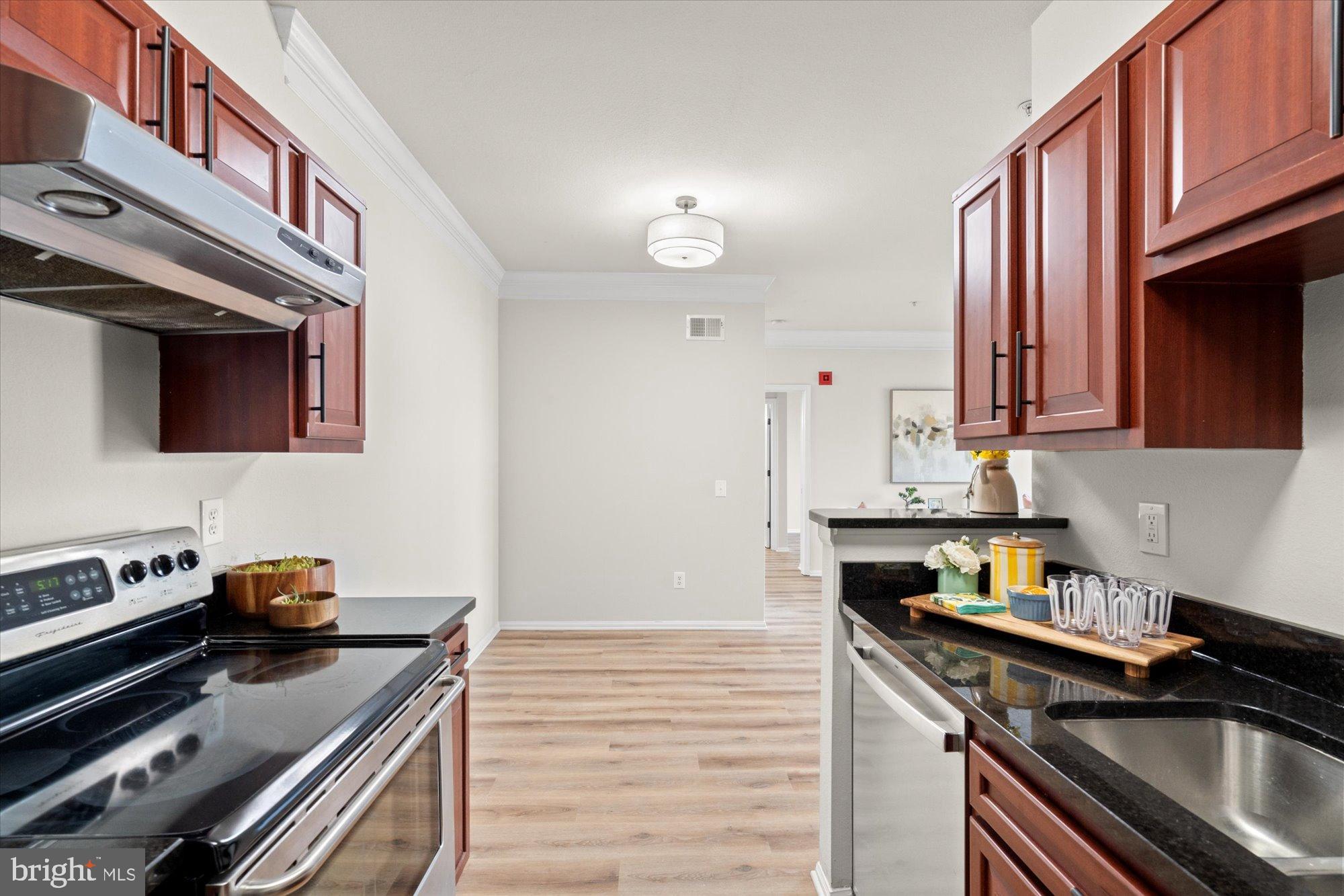 1571 Spring Gate Dr., Unit 6213 McLean, VA 22102 - Photo 8 of 39 a kitchen with stainless steel appliances a stove a sink dishwasher and cabinets with wooden floor