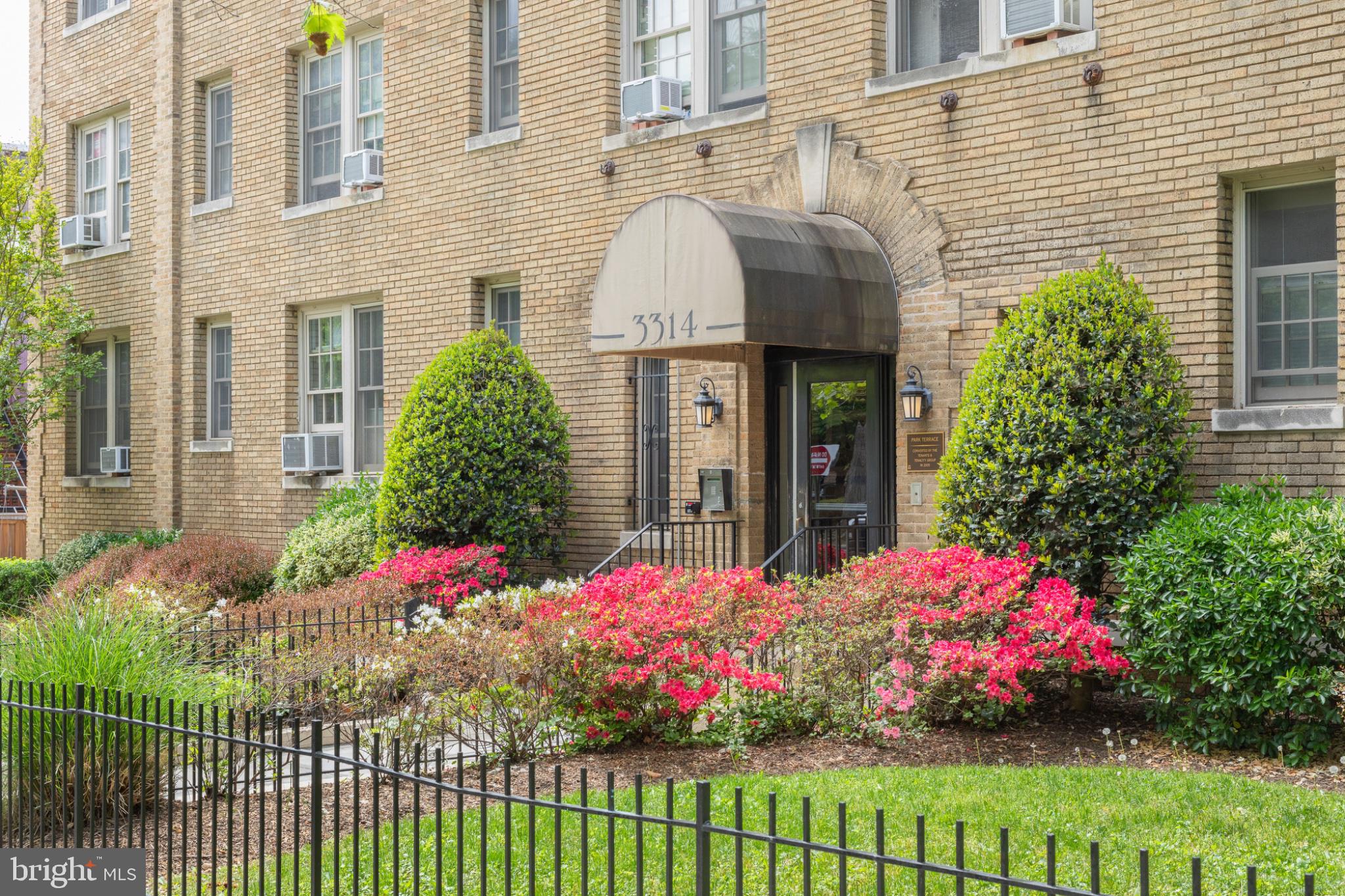 Charming brick facade with vibrant blooms.
