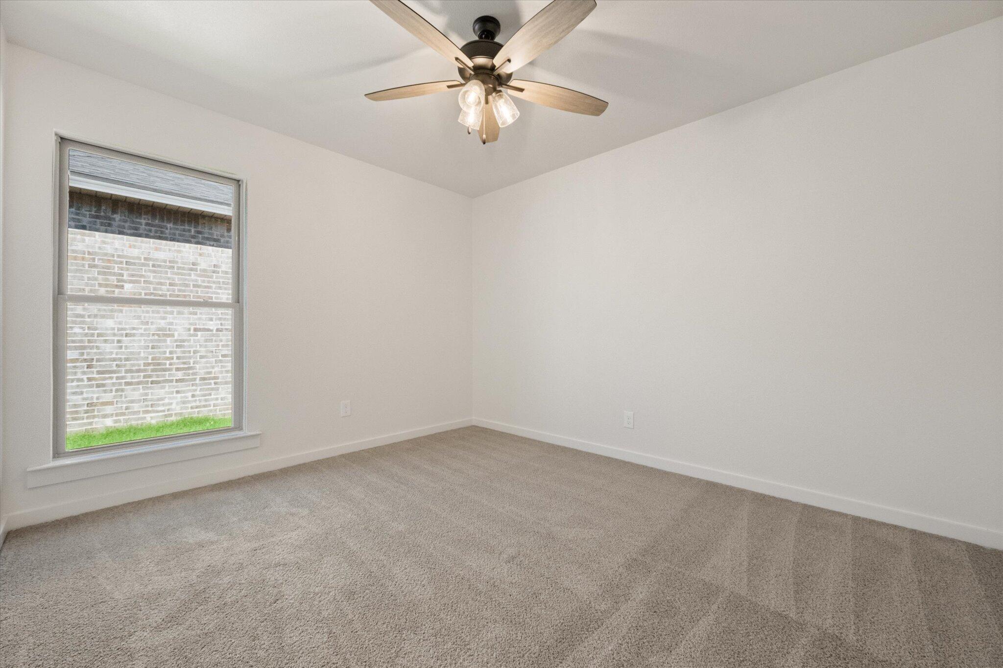 7003 53rd Street Lubbock, TX 79407 - Photo 22 of 25 an empty room with a window and a fan