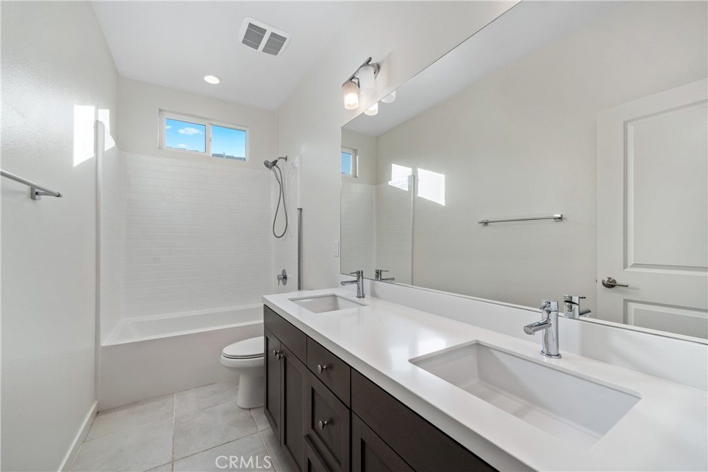 11082 Panoramic Drive Rancho Cucamonga, CA 91730 - Photo 27 of 48 a bathroom with a double vanity sink a toilet and shower