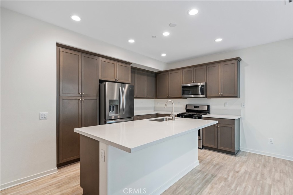 11082 Panoramic Drive Rancho Cucamonga, CA 91730 - Photo 3 of 48 a kitchen with a refrigerator a sink and cabinets