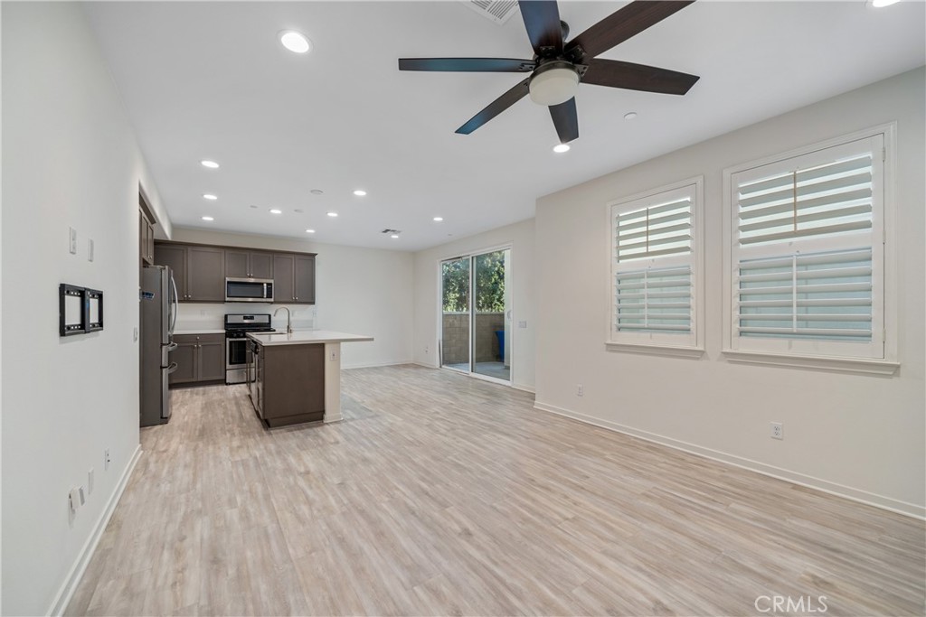 11082 Panoramic Drive Rancho Cucamonga, CA 91730 - Photo 6 of 48 a large kitchen with stainless steel appliances kitchen island a large counter top and a wooden floor