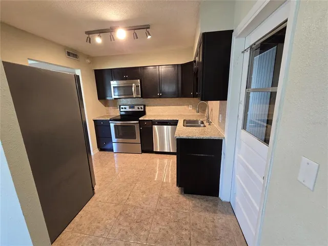 a large kitchen with a sink a refrigerator and a stove