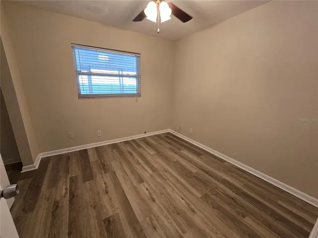 a room with a bed and a chandelier fan