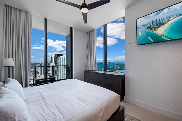 a bedroom with a large bed and a chandelier
