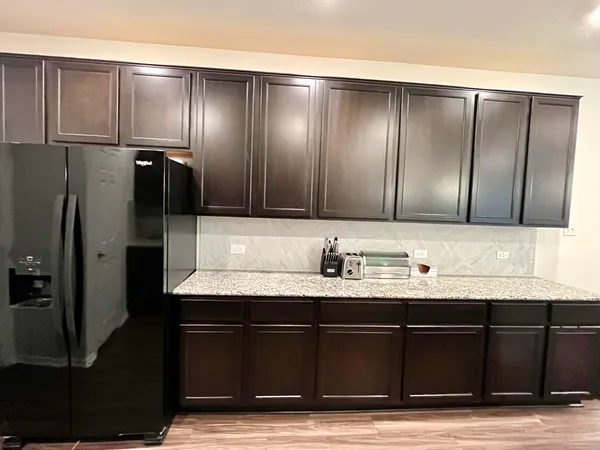 a kitchen with stainless steel appliances granite countertop a stove a microwave and a refrigerator