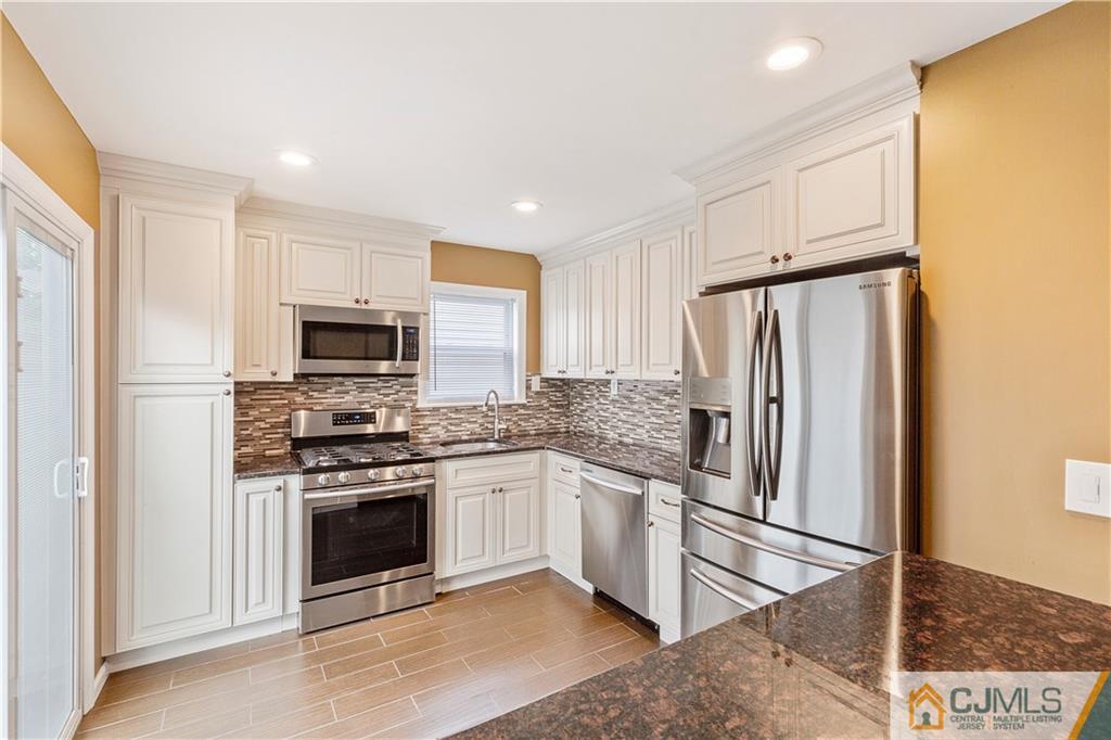 a kitchen with stainless steel appliances granite countertop a stove a refrigerator and a microwave