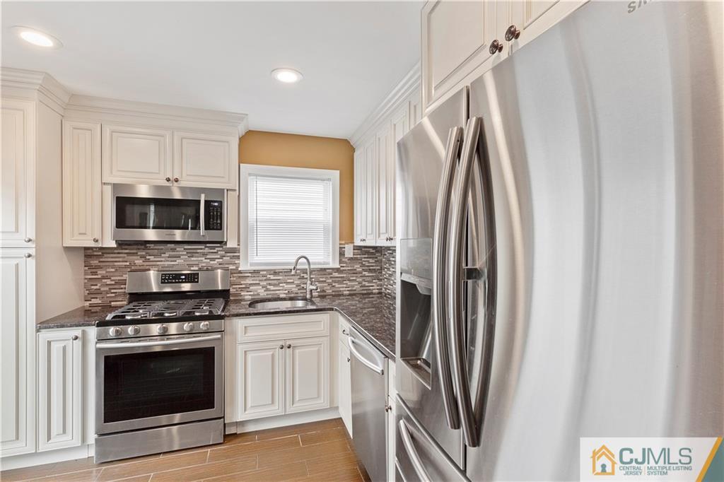 63 Daniel Street Carteret, NJ 07008 - Photo 2 of 20 a kitchen with stainless steel appliances a stove microwave and a refrigerator