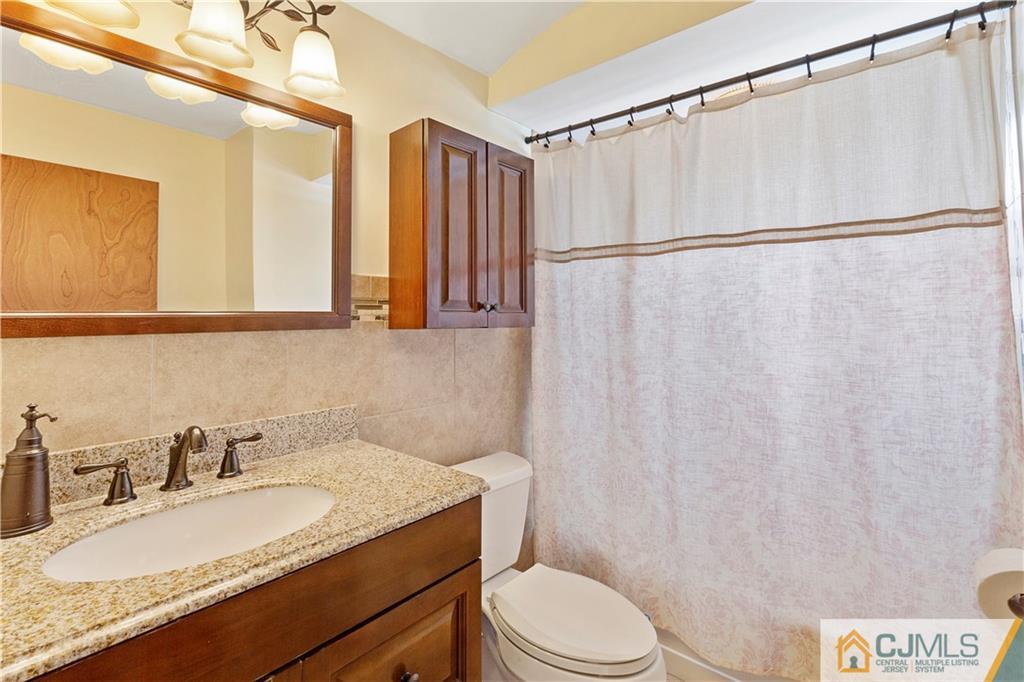 63 Daniel Street Carteret, NJ 07008 - Photo 13 of 20 a bathroom with a granite countertop sink and a mirror