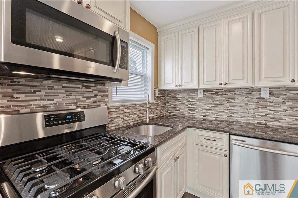 63 Daniel Street Carteret, NJ 07008 - Photo 3 of 20 a kitchen with granite countertop a stove and a sink
