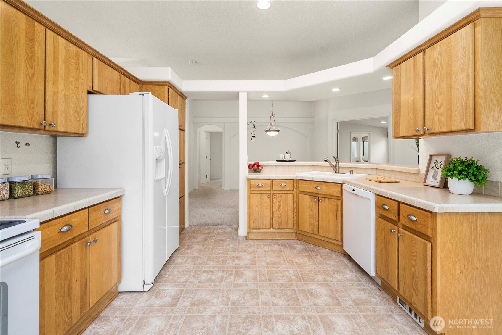 9806 196th Street East Graham, WA 98338 - Photo 13 of 31 a kitchen with a sink refrigerator and cabinets
