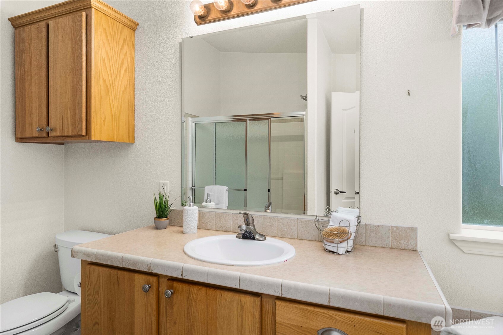 9806 196th Street East Graham, WA 98338 - Photo 24 of 31 a bathroom with a granite countertop sink and a mirror
