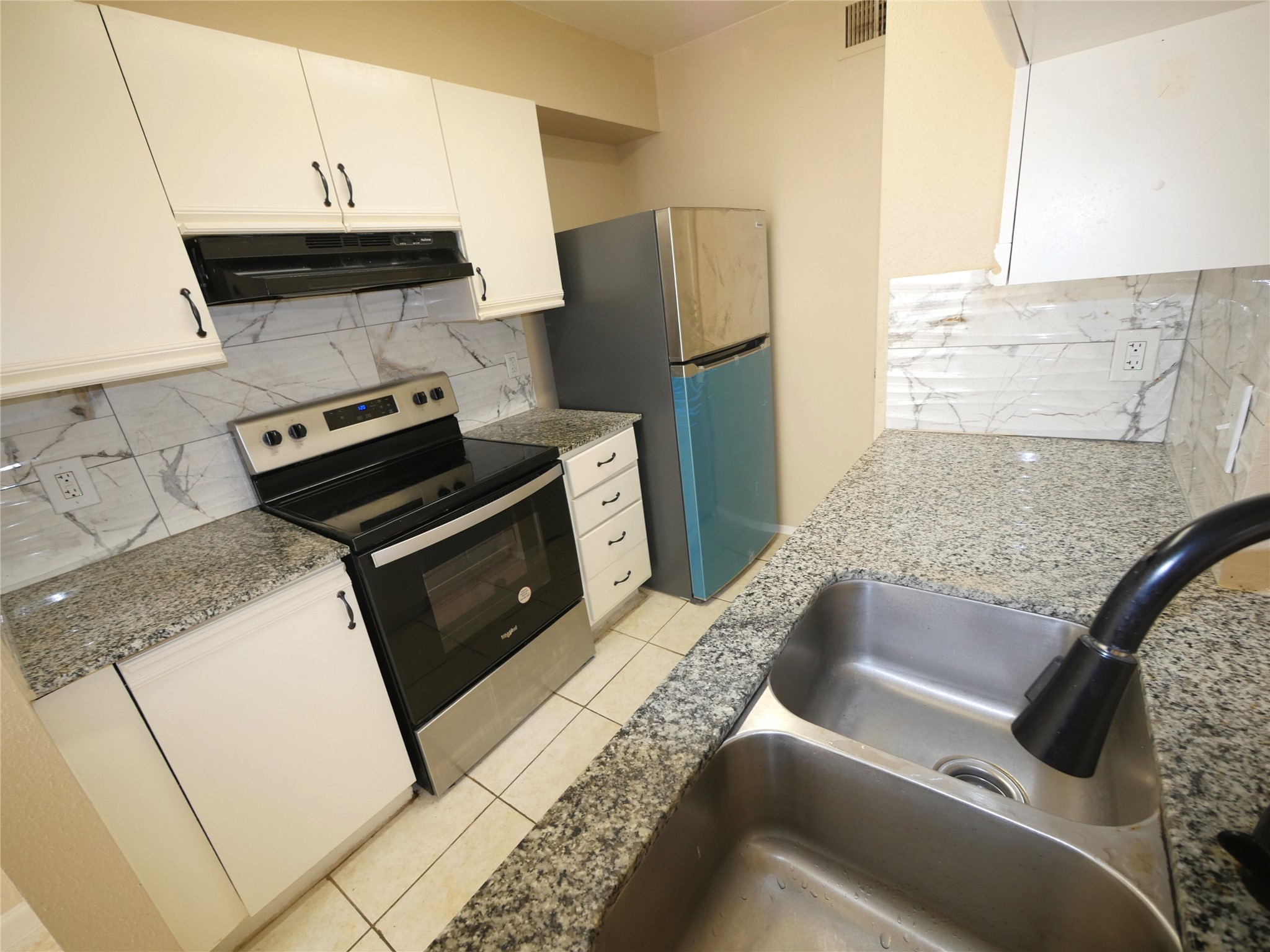 10100 South Gessner Road, Unit 202 Houston, TX 77071 - Photo 6 of 9 a kitchen with a stove and a microwave