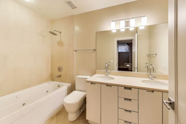 a bathroom with a sink a toilet and a large mirror