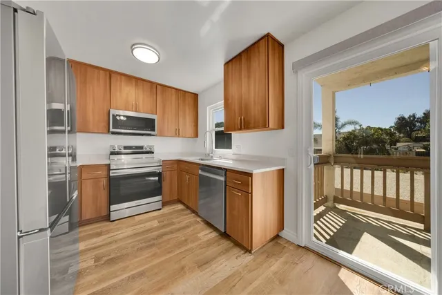 a kitchen with stainless steel appliances granite countertop a stove a sink and a refrigerator
