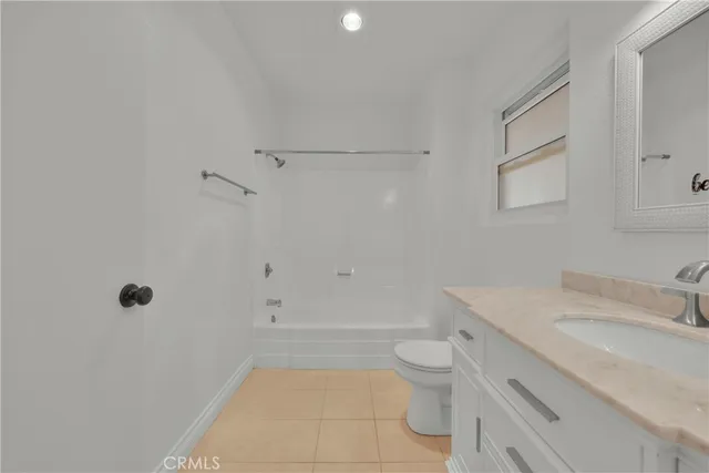 a bathroom with a granite countertop sink a toilet and shower