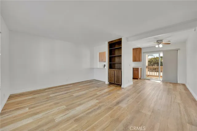 an empty room with wooden floor and natural light